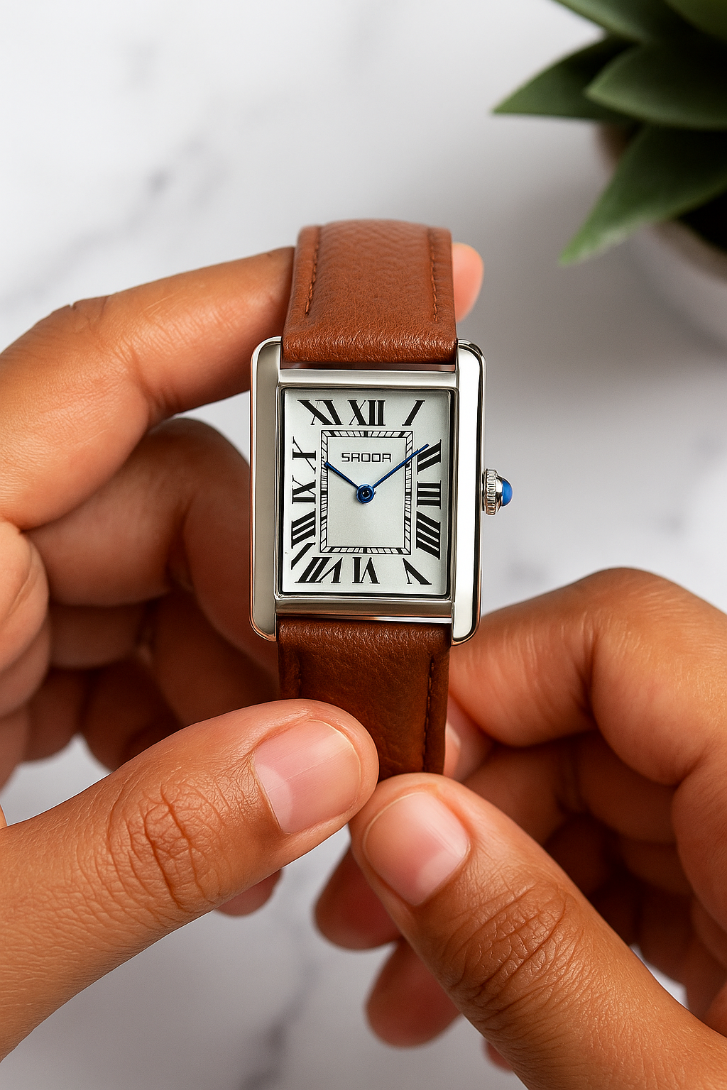 Person holding a rectangular watch with a brown leather strap against a blurred background. Sanda 1108 brown leather belt.